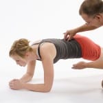 therapist helping patient with plank pose